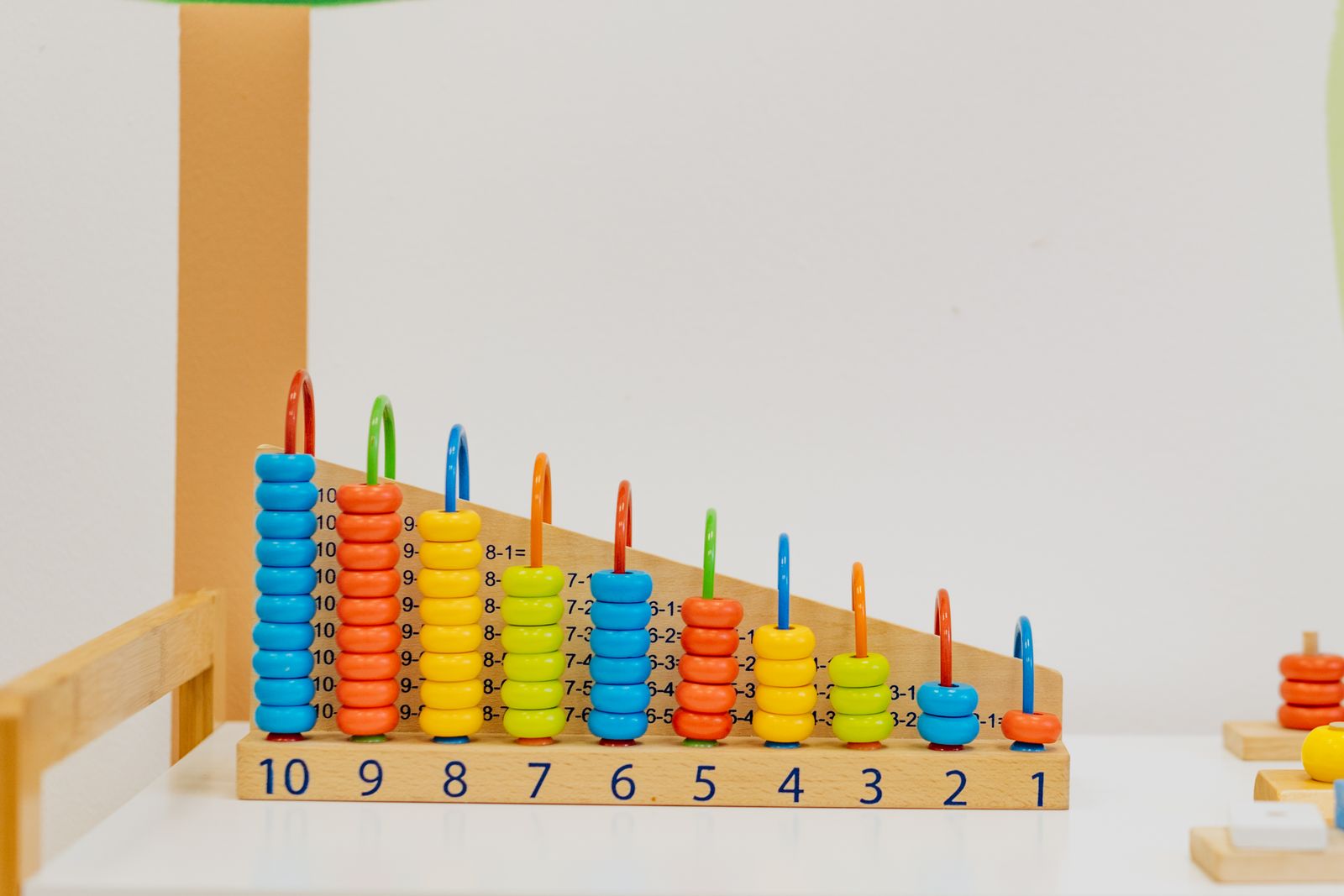 A wooden counting frame with colorful beads numbered one to ten